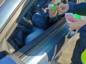 policjant przekazuje niewielkie gadżety w ramach akcji kierowcy