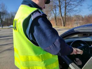 policjant przekazuje niewielkie gadżety w ramach akcji kierowcy
