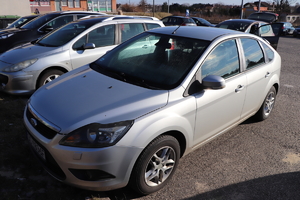 samochód marki Ford koloru srebrnego zaparkowany na parkingu - na zdjęciu widać lewy bok pojazdu