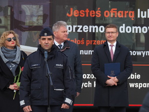 kierownictwo częstochowskiej Policji wspólnie z władzami miasta i współorganizatorami stoją na tle autobusów miejskich podczas briefingu na Placu Biegańskiego