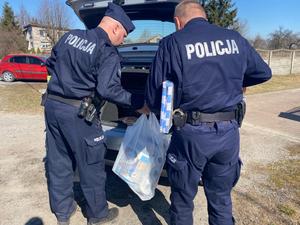 policjanci wypakowują z bagażnika zebrane rzeczy dla rodziny z Ukrainy