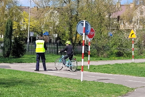 policjanci na miasteczku rowerowym oceniają jeżdżących na rowerze uczniów