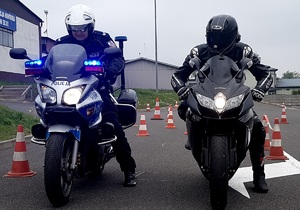 policjant na motocyklu, obok motocyklista - pozują do zdjęcia