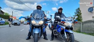 dwóch policjantów na motocyklach pozuje do zdjęcia