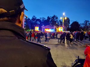 zbliżenie na policjanta, który patrzy na scenę na Placu Biegańskiego, wokół sceny zgromadzeni ludzie