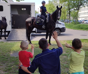 policjantka na koniu i policjant podczas spotkania z uczniami szkoły przed budynkiem