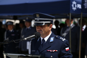 policjant stoi przed mównicą i przemawia do uczestników uroczystości