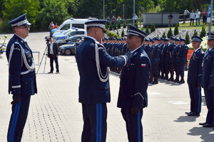 I Zastępca Komendanta Głównego Policji nadinspektor Dariusz Augustyniak przypina odznakę do munduru młodszemu inspektorowi Dariuszowi Kiedrzynowi (fotografia Śląskiej Policji)