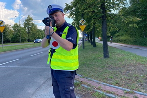 policjant mierzy prędkość przejeżdżającym pojazdom