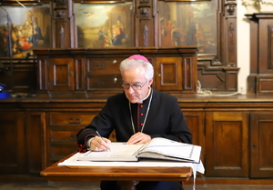 biskup dokonuje wpisu do księgi pamiątkowej Komendy Miejskiej Policji w Częstochowie