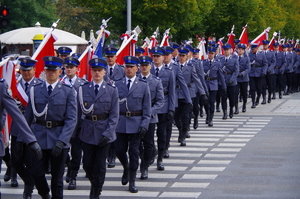 przemarsz kolumn policjantów w mundurach alejami