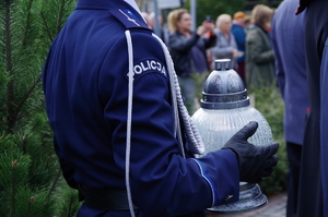 zbliżenie na duży znicz, który trzyma policjant