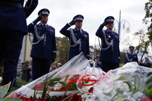 delegacja policjantów i ksiądz przed pomnikiem w alei Sienkiewicza