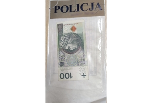banknot 100 złotych w woreczku z napisem Policja