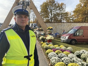 zbliżenie na twarz policjanta, który stoi przy cmentarzu