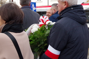 zbliżenie na barwy białe i czerwone osób maszerujących pod pomnik