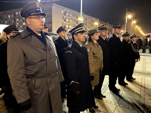 przedstawiciele służb mundurowych stoją w szeregu przed złożeniem wieńca przy pomniku Marszałka Józefa Piłsudskiego