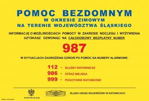 plakat z napisami na żółtym tle - pomoc bezdomnym w okresie zimowym na terenie województwa śląskiego, telefon 987, w sytuacjach zagrożenia dzwoń pod numery alarmowe 112, 986, 999.