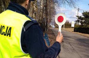 Policjant trzyma ręce tarczę do zatrzymywania pojazdów