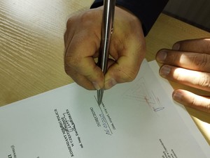 Długopis w ręce którym podpisywany jest dokument