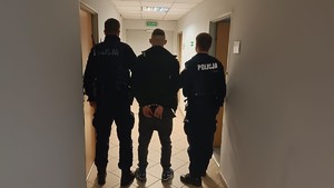 Policjanci doprowadzają zatrzymanego