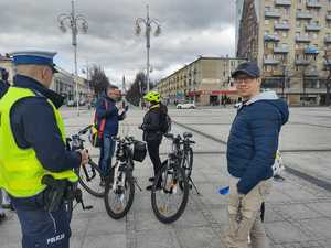 Rowerzyści rozmawiają z policjantem i dziennikarzem