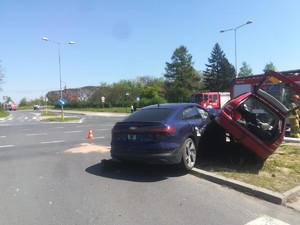 Zniszczone pojazdy na drodze. W tle stoją strażacy i wóz strażacki