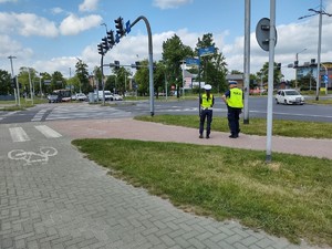 Skrzyżowanie przy którym policyjny patrol obserwuje ruch pojazdów