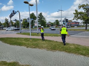 Policjanci idą w kierunku skrzyżowania