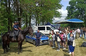 Policyjni jeźdźcy konno rozmawiają z dziećmi na podwórku