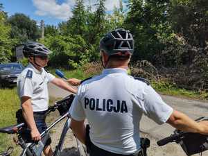 Policyjny patrol rowerowy stoi w rejonie służbowym, obok nich stoją ich rowery