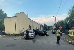 Miejsce zdarzenia- wywrócony pojazd na dach, obok inne pojazdy i strażacy oraz policjant