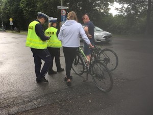 Rowerzyści rozmawiają z policjantami, którzy prowadza akcję na drodze