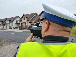 Policjant mierzy prędkość poruszającego się pojazdu