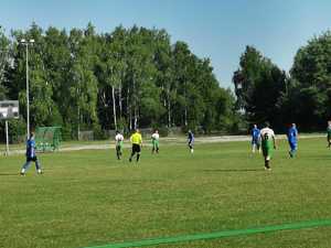 Kilku piłkarzy w trakcie rozgrywania meczu na boisku sportowym.