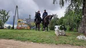 Policyjny patrol na koniach stoi przy rozwiedzionym plakacie