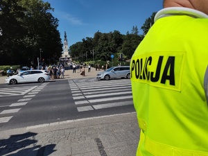 Policjant stoi przy skrzyżowaniu i strzeże bezpieczeństwa w ruchu