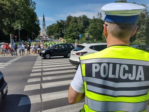 Policjant przed przejściem dla pieszych koordynuje ruch pojazdów i pieszych