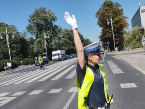 Policjantka unosi prawa rękę do góry