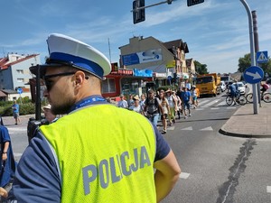 Policjant na drodze dba o bezpieczeństwo podczas przemarszu pielgrzymów