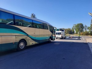 Autokar wjeżdżający na parking, gdzie rozłożono mobilną stację diagnostyczną