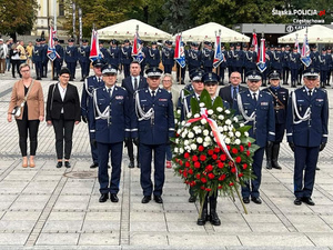 Policyjna delegacja idzie z wiązanka kwiatów