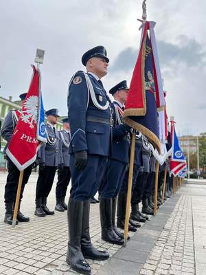 Policjanci stoją ze sztandarami na placu Biegańskiego