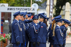 Policjanci stoją w grupie i śpiewają do mikrofonów- policyjny chór