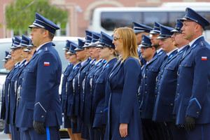 Policjanci stoją w szyku zwróceni w jednym kierunku