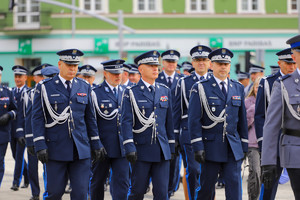 Policjanci idą w szyku do miejsca zbiórki