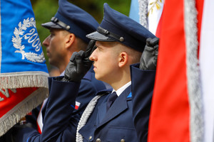 Policjanci na tle sztandarów