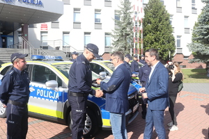Policjant odbiera kluczyki od delegacji kilku mężczyzn