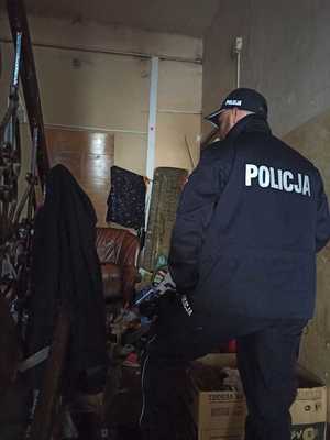 Policjanta sprawdza opuszczone pomieszczenia w poszukiwaniu osób bezdomnych