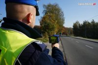 Policjant mierzy prędkość pojazdów urządzeniem